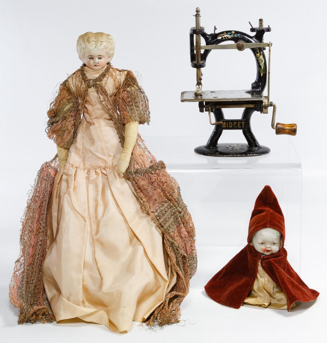 Midget Toy Sewing Machine and Bisque Doll Assortment: Midget Toy Sewing Machine and Bisque Doll Assortment Three items including a painted cast iron 'Midget' hand crank sewing machine, a 'Low Brow' bisque shoulder head doll on cloth body and a Japanese b