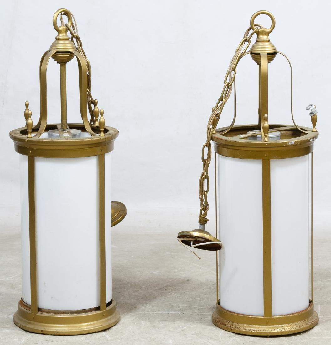 Architectural Lamps: Architectural Lamps Two ceiling fixtures having white glass cylinders inside a cast metal frame painted gold, each having three lights and ceiling cap Height: 34.50 inches, Diameter: 12.00 inches (wit