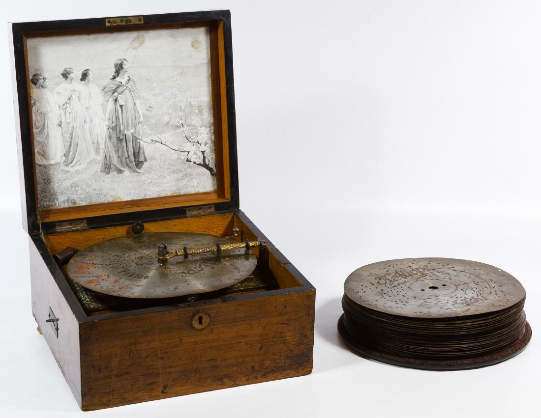 German Kalliope Music Box and Disc Assortment: German Kalliope Music Box and Disc Assortment Having a Timbro Variante mark on the mechanism, serial #48250 on the brass under plate and on the arm, a walnut housing, a crank and (24) tin 9.25' diamet