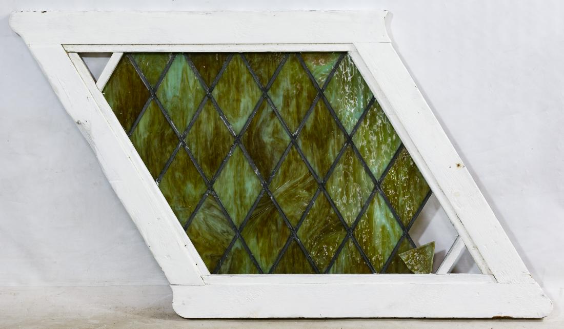 Stained Glass Window: Stained Glass Window Having a painted wood diamond shaped frame with green to brown tone slag glass panes Length: 65.00 inches, Width: 40.00 inches Category: Decorative Arts > Windows Shipping Status: