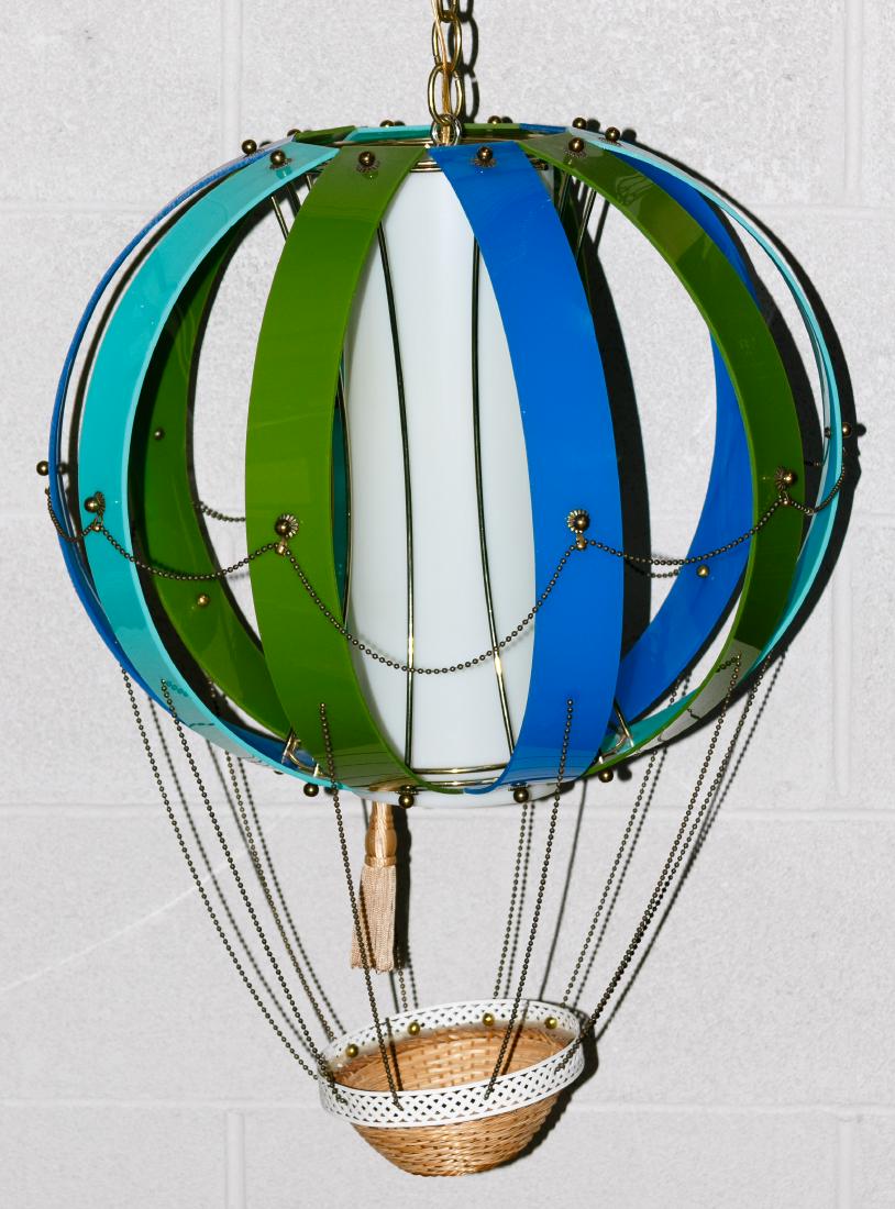 Hot Air Balloon Hanging Lamp: Hot Air Balloon Hanging Lamp Plastic hanging light fixture having multi-color ribs around a white tube with a wicker basket hanging off the bottom and a brass chain with an extension cord Height: 26.0