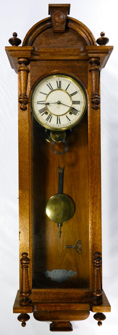 Ansonia Walnut and Glass Cased Wall Clock: Ansonia Walnut and Glass Cased Wall Clock Having a classical style case, painted dial, chiming mechanism, pendulum and key Height: 47.00 inches, Width: 13.50 inches Category: Decorative Arts > Clocks