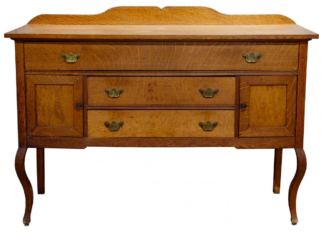 Colonial Style Oak Buffet: Colonial Style Oak Buffet Paneled oak buffet having a long and two shorter dovetailed drawers, two compartments having paneled doors, cabriolet front legs and brass hardware Condition: Very Good, over