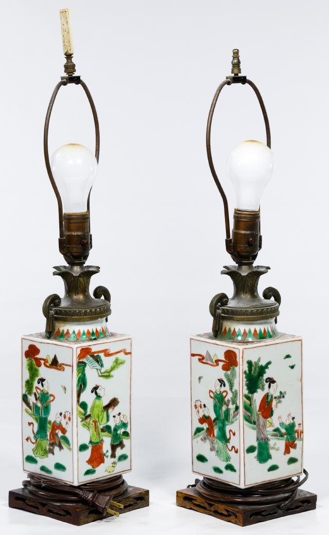 Asian Ceramic Table Lamps: Asian Ceramic Table Lamps Square porcelain jars having mirror images on all sides, green and red on white, leaf shaped bronze lids and harps, mounted on carved wooden bases Condition: Good, jars drill