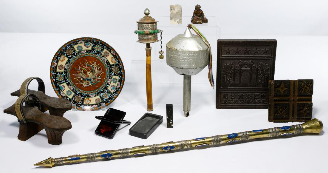 Asian Decorative Object Assortment: Asian Decorative Object Assortment Twelve items including compressed Chinese brick tea, a pair of wooden Mandarin high heel shoes, a metal enameled wall plate, a square wooden stamp, Chinese ink and i
