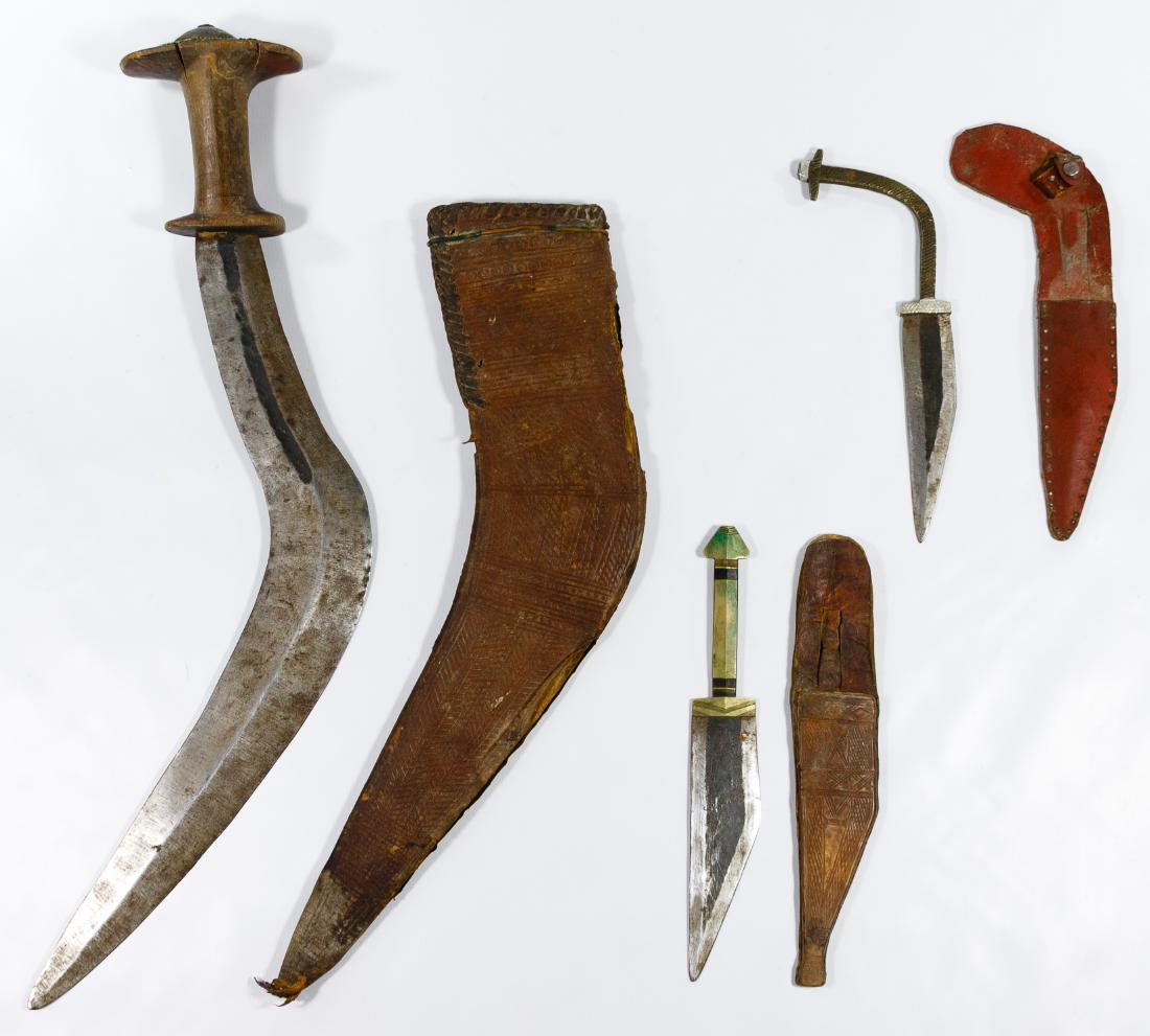 East Indian Edged Weapon Assortment: East Indian Edged Weapon Assortment Three items including a 'kukri' machete used by the Gurkas of Nepal and India having a tooled leather sheath and two tribal 'jambiya' daggers having leather sheaths