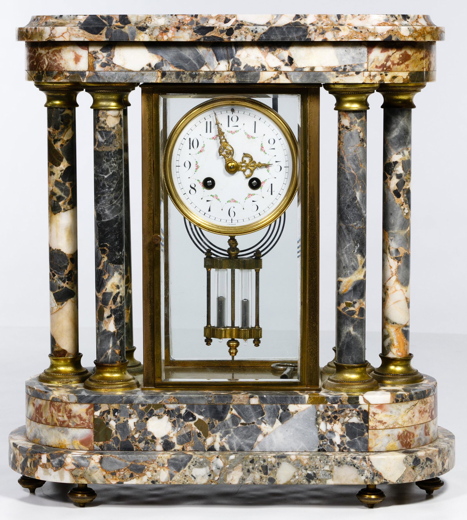 French Marble Mantel Clock: French Marble Mantel Clock Having a porcelain dial marked 'France', marble pillars and base, pendulum and key; interior clock case marked '8829' Condition: Good, overall light wear, top ornament missi