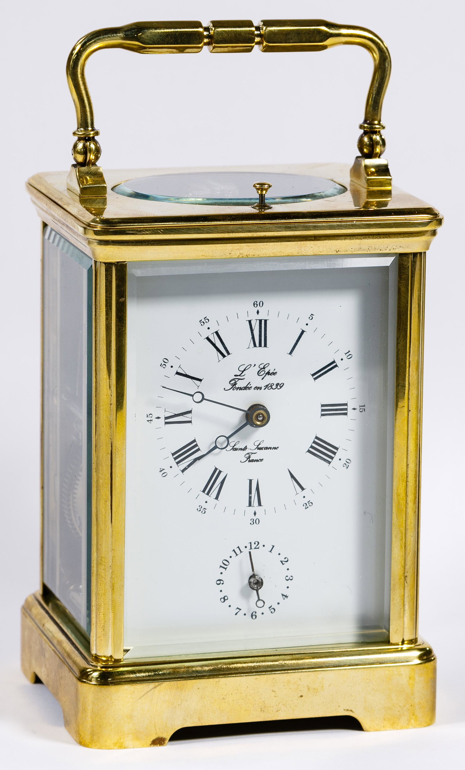 Le Eppe Carriage Clock: Le Eppe Carriage Clock Brass case having beveled glass sides, enameled roman numeral face, 11-jewel movement; including key Condition: Very Good, overall light wear consistent with age and normal use;