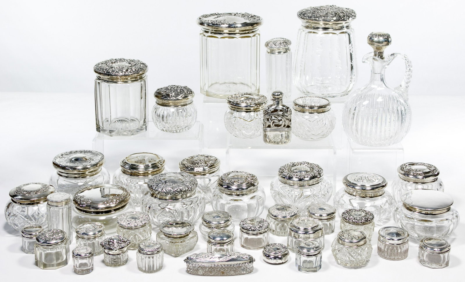 Sterling Silver Lidded Vanity Jar Assortment: Sterling Silver Lidded Vanity Jar Assortment Forty items including thirty-seven jars, a pitcher with stopper, a flask and trinket box; most marked 'sterling' Condition: Good, light wear consistent wit