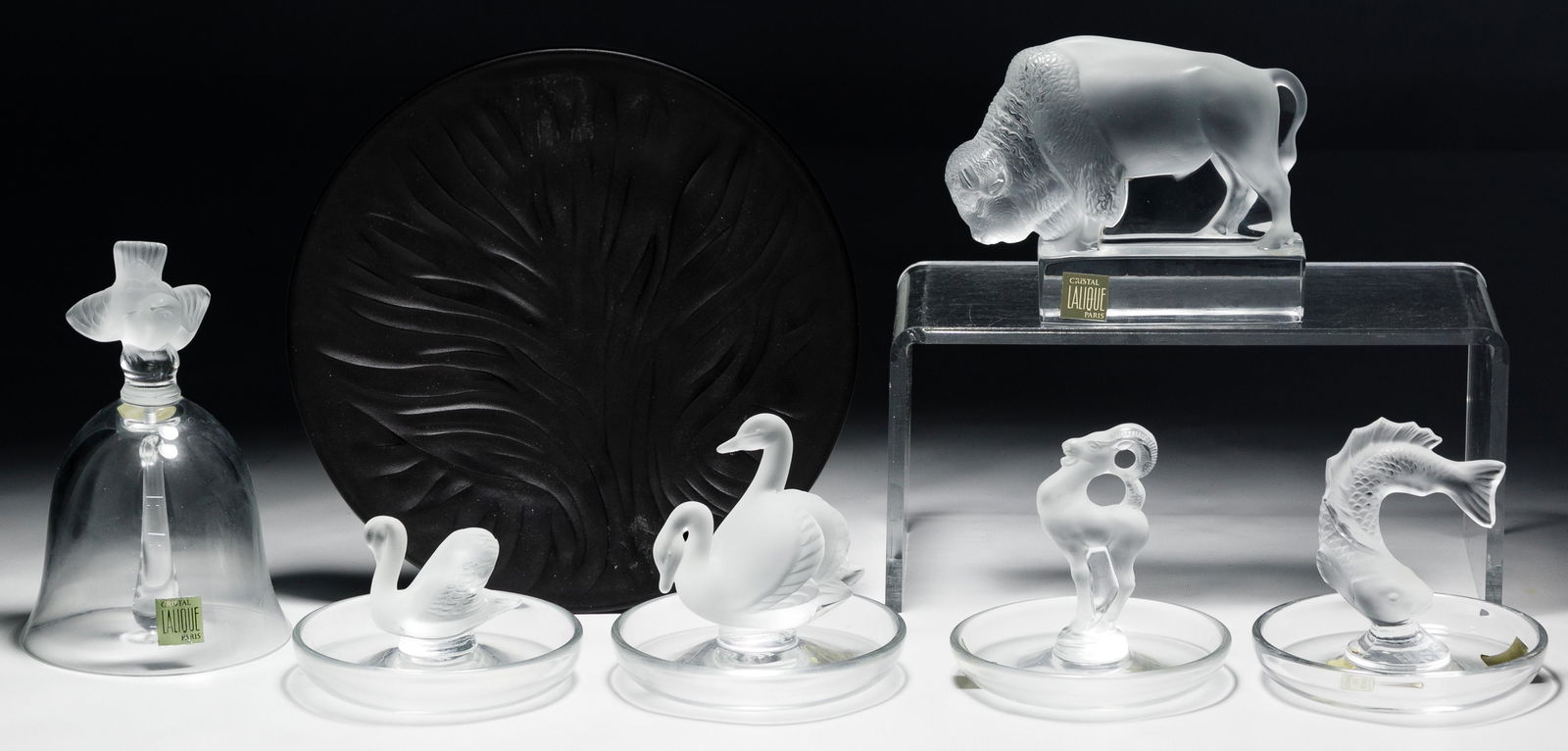 Lalique Crystal Assortment: Lalique Crystal Assortment Six items including four ring holders as well as a bell, a buffalo figurine and a black 'Sea of Life Tree' plate; all etched 'Lalique' on underside, some having original lab
