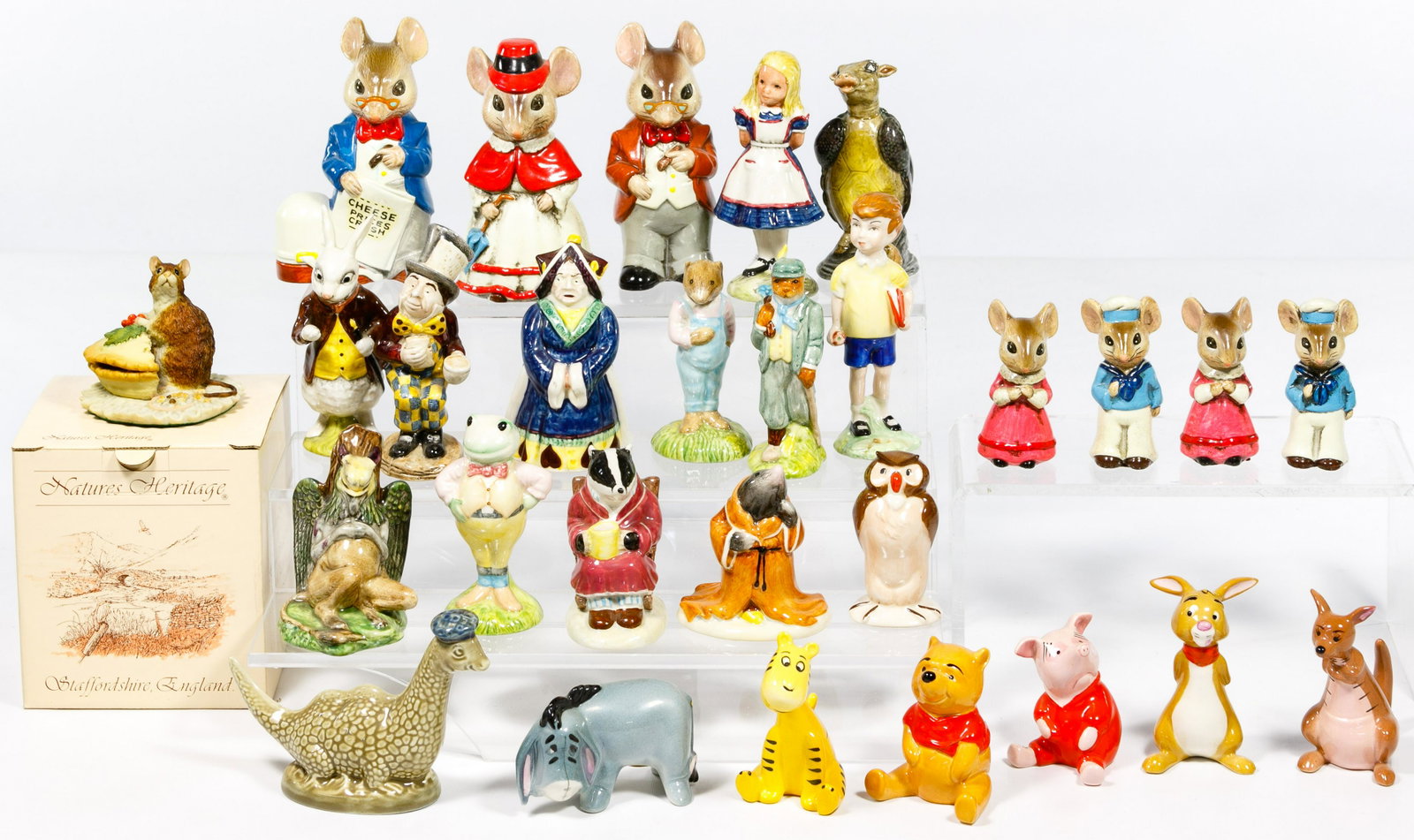 Porcelain and Ceramic Figurine Assortment: Porcelain and Ceramic Figurine Assortment Twenty-eight items including the 'Alice in Wonderland', the 'Winnie the Pooh' series the 'Wind and the Willows 'series Condition: Very Good, ; overall light w