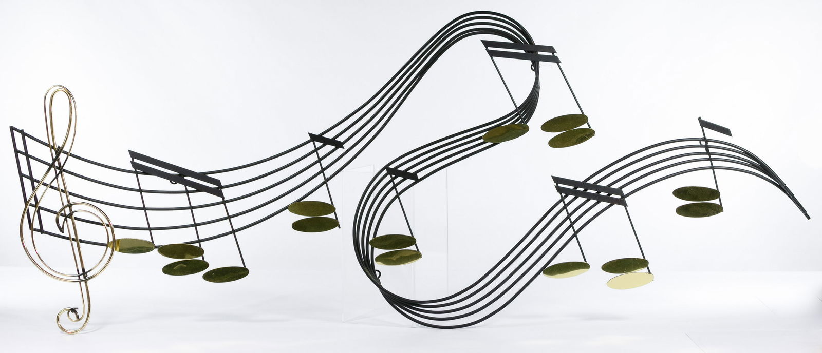 Curtis Jere (American, 1910-2008) Metal Sculpture: Curtis Jere (American, 1910-2008) Metal Sculpture 1987, signed lower right, wall hanging that depicts a dramatically curved bar of music, made of black and gold-tone metal Condition: Very Good, no dam