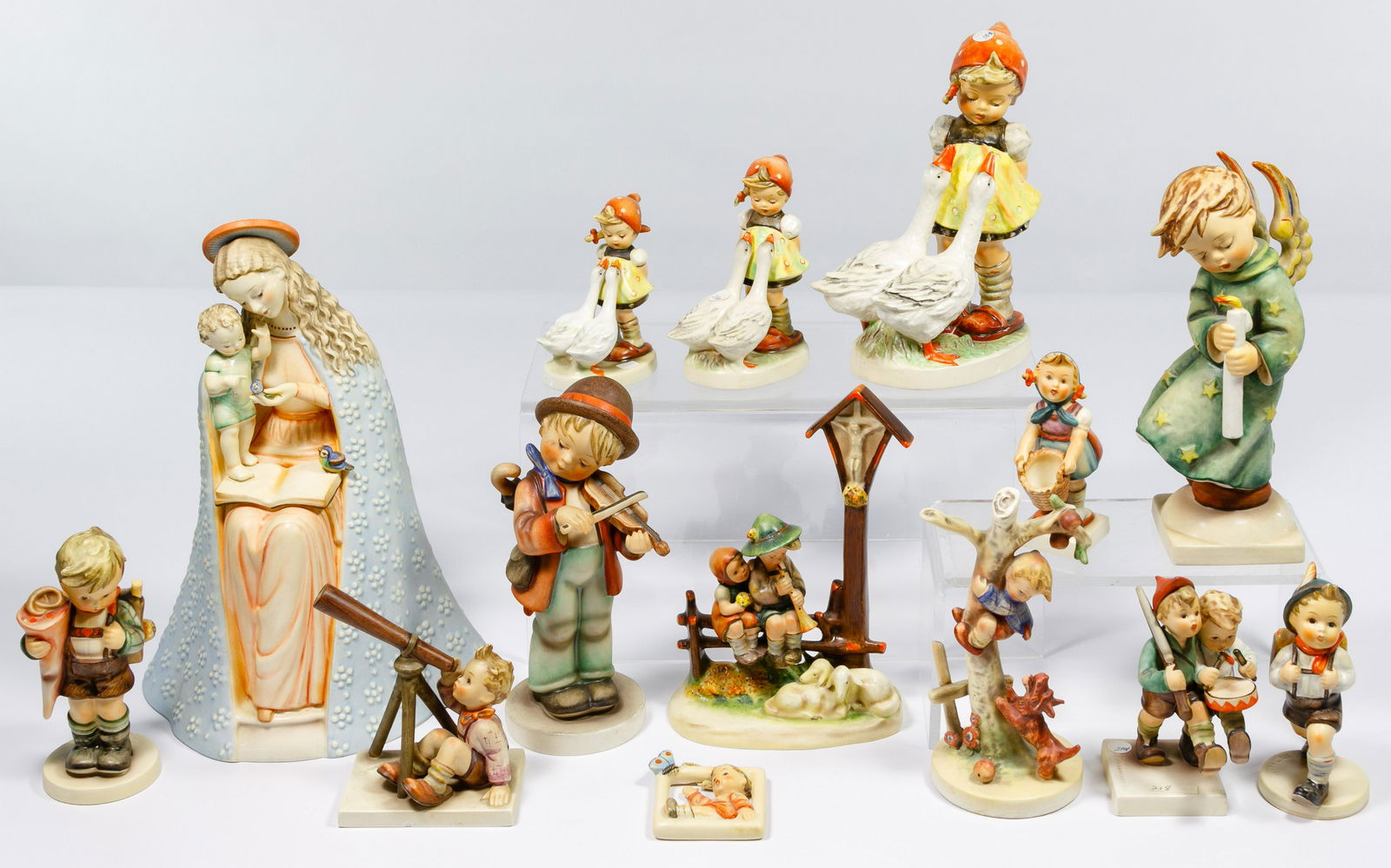 Hummel / Goebel Figurine Assortment: Hummel / Goebel Figurine Assortment Fourteen items including #10/1 'Flower Madonna', #47/II, #47/0 and #47 3/0 'Goose Girl', #21/II 'Heavenly Angel', #2/I 'Little Fiddler', #28/2 'Wayside Devotion', #