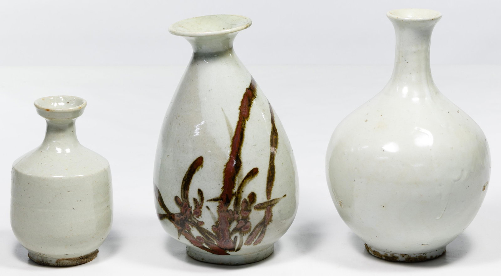 Korean Baekja Vase Assortment: Korean Baekja Vase Assortment Three white pottery vases, with one having a brown glaze floral motif Condition: Very Good to Good, floral motif vase having a repaired crack, overall light wear consiste