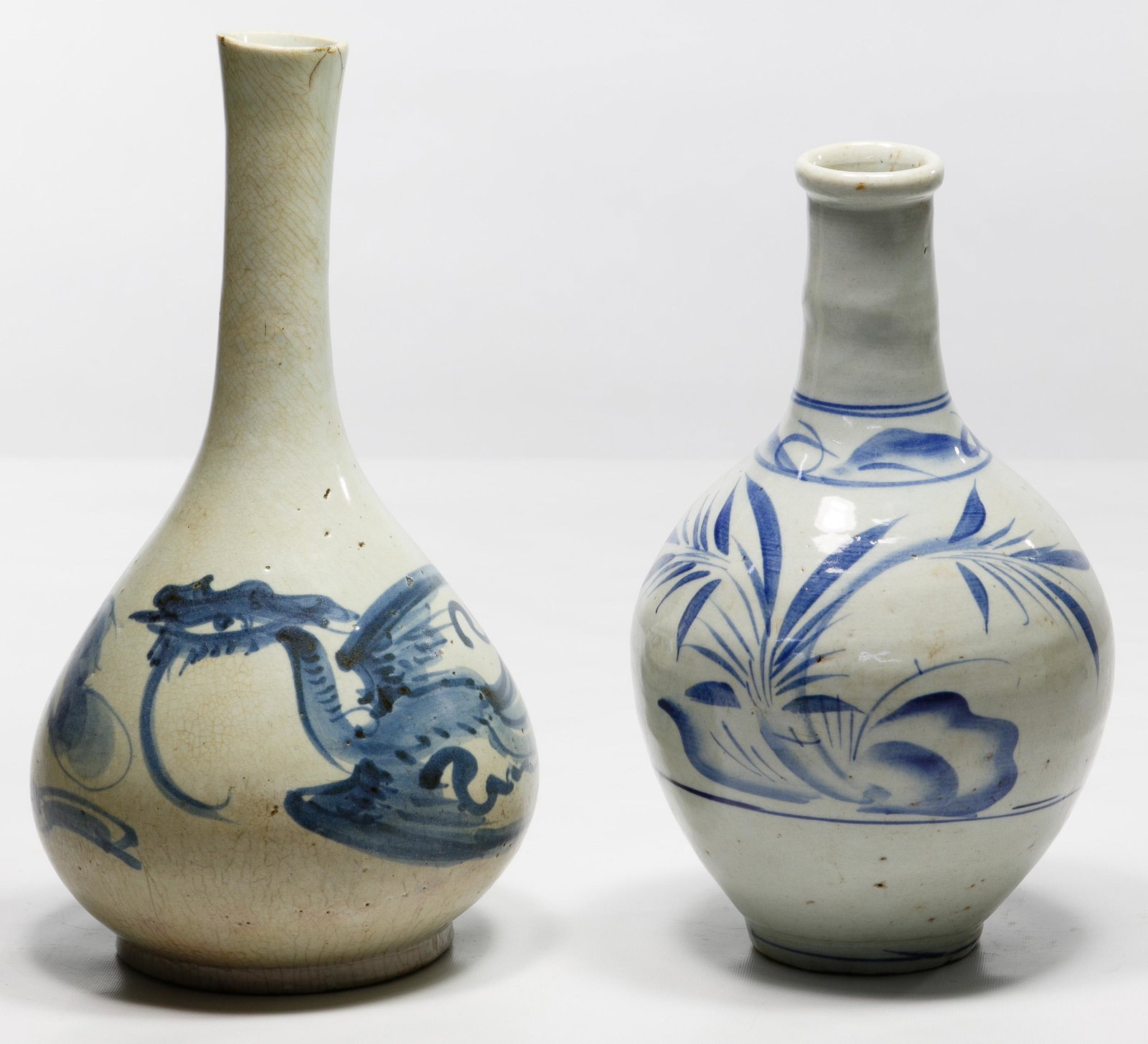 Korean Blue on White Sake Bottles: Korean Blue on White Sake Bottles Two Korean blue and white bottle vases including a pear shape rising to a tall neck with an underglaze blue phoenix and the other having floral decoration Condition: 