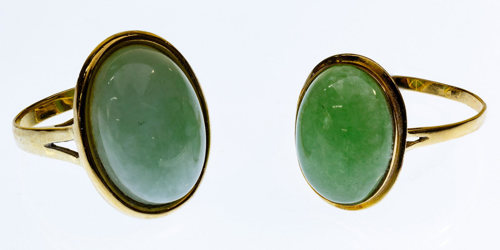 14k Gold and Jadeite Jade Rings: 14k Gold and Jadeite Jade Rings Both having oval cut cabochon jadeite jade, one measuring 18mm by 13mm, the other 15mm by 11mm; larger gemstone ring marked '14k' inside band Condition: Very Good, over