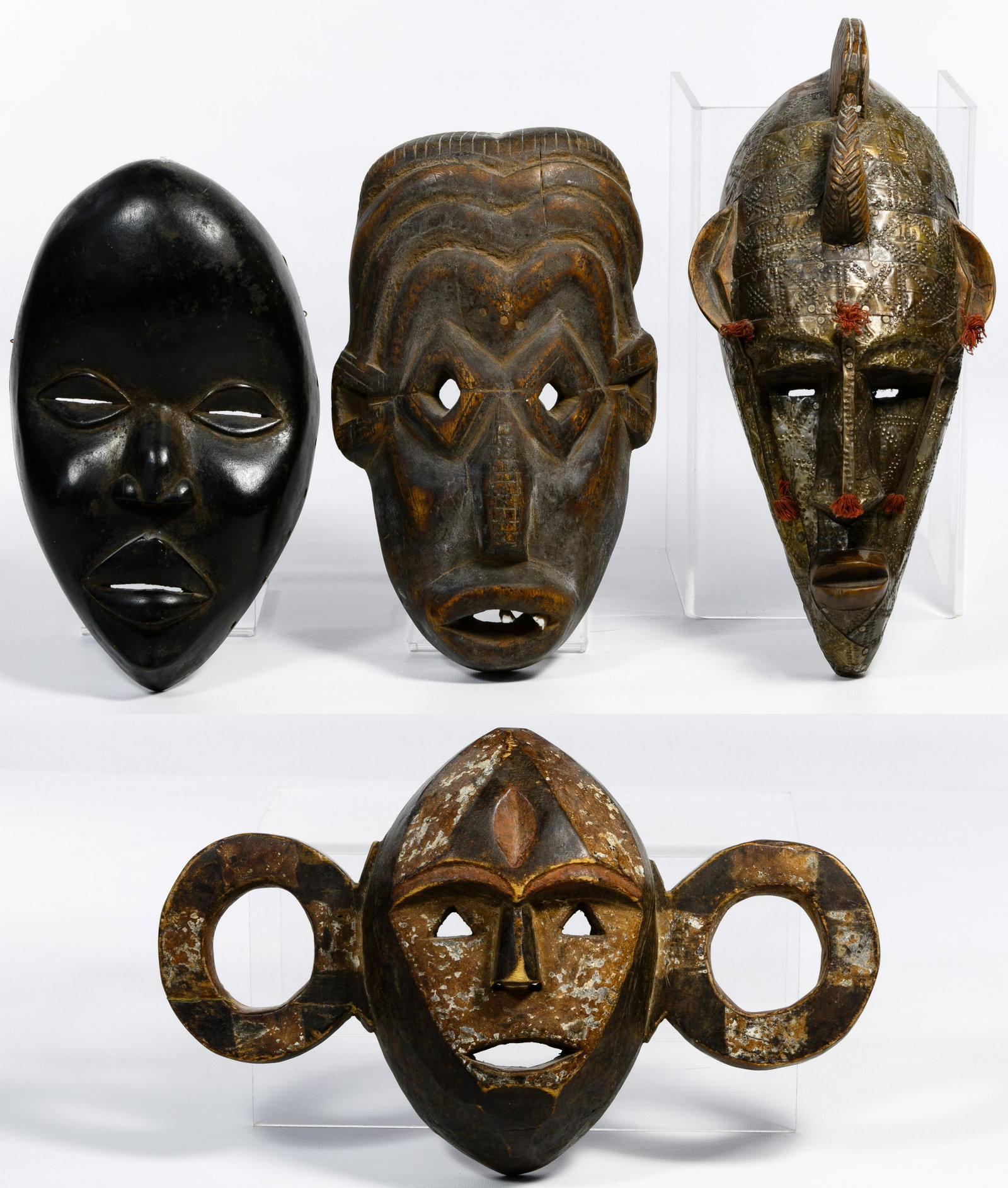 African Mask Assortment: African Mask Assortment Four items including a mask depicting a monkey, one with a punched metal overlay, two having simplistic carvings with one having teeth Condition: Very Good to Good, overall mod
