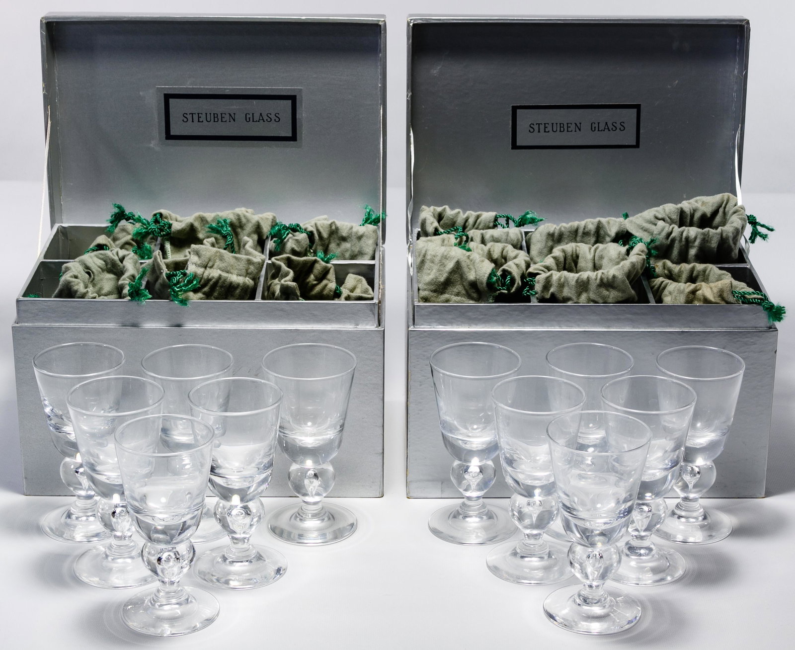 Steuben '7877' Wine Glass Collection: Steuben '7877' Wine Glass Collection Twelve items, clear glass with baluster stem, all in original felt bags and Marshal Field's boxes Condition: Very Good, light wear, foot of one glass chipped, boxe