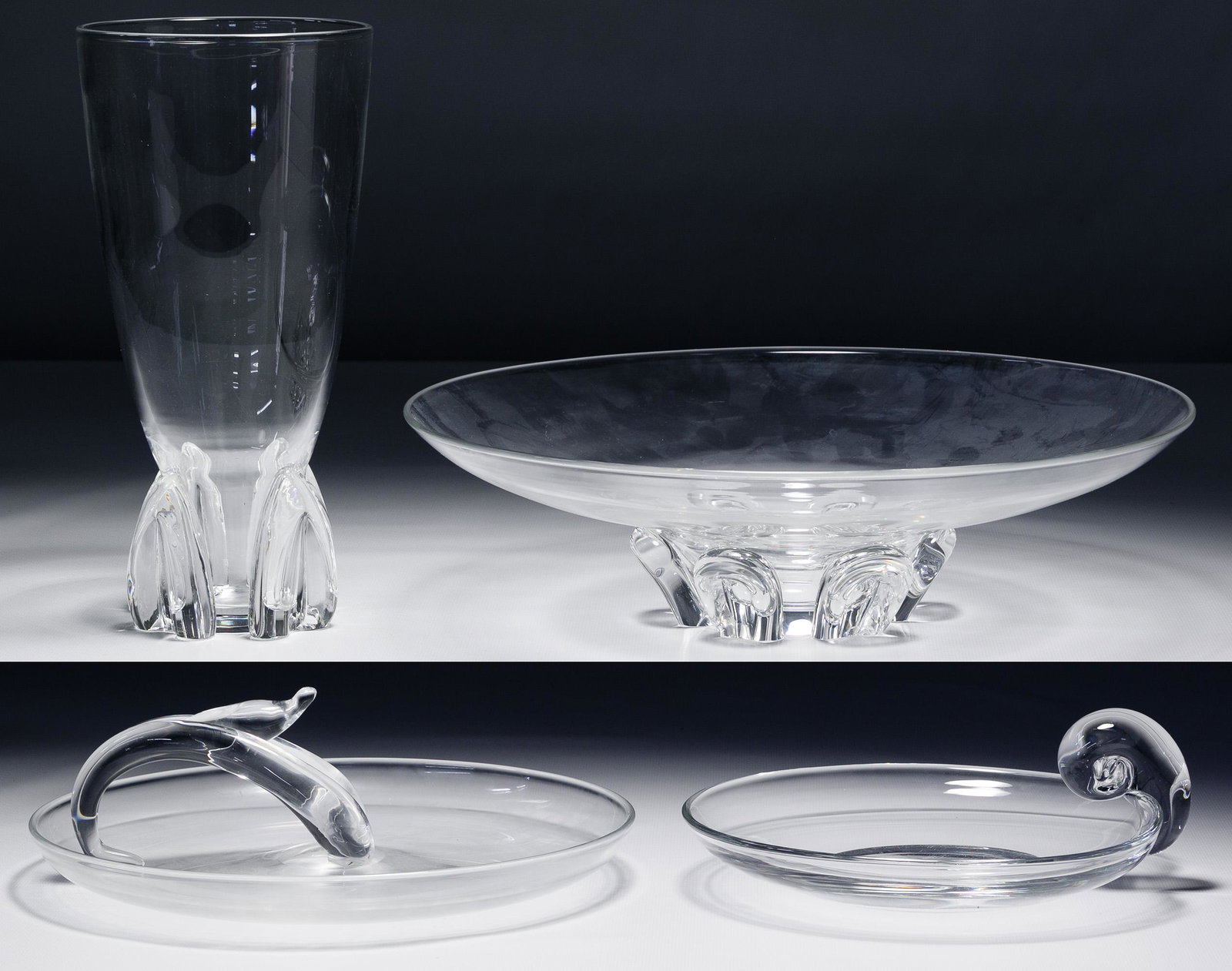 Steuben Glass Assortment: Steuben Glass Assortment Four items including a bouquet vase, a large center dish, a scroll handle dish and a wave handled dish; all signed on underside Condition: Very Good, light wear, some scratche