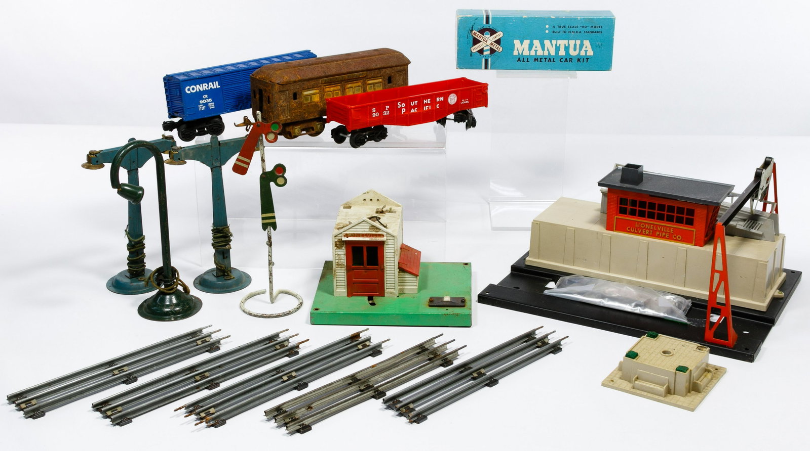 Lionel Model Train Assortment: Lionel Model Train Assortment Including a Type R 100 Watt 'TRAINmaster' transformer, two Lionelville Culvert Pipe Co. loading platforms, a metal Pullman Parlor Car, two plastic freight cars, bags of p
