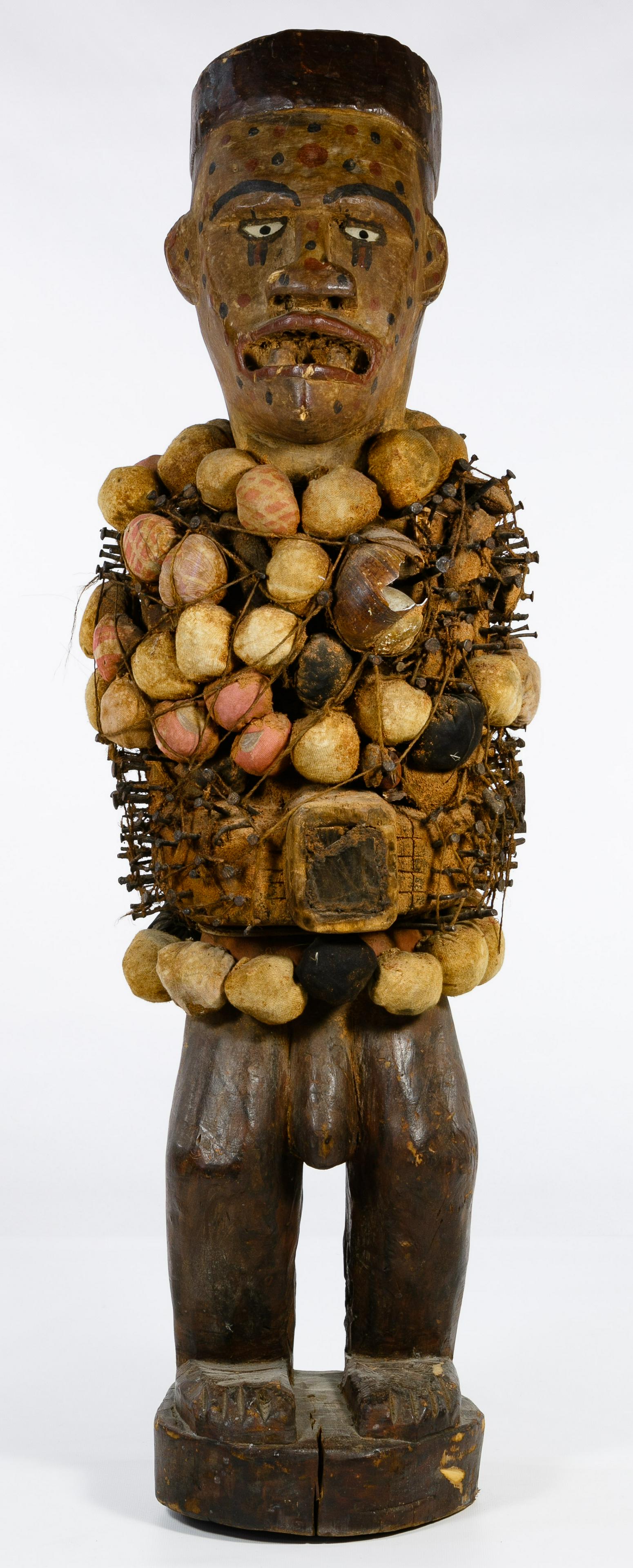 African Yombe Fetish Sculpture: African Yombe Fetish Sculpture 20th century Mayombe / Yombe carved and painted wood Nkisi power figure / fetish, having iron nails, textile wrapped fetish bundles, seashells and glass insets at eyes a