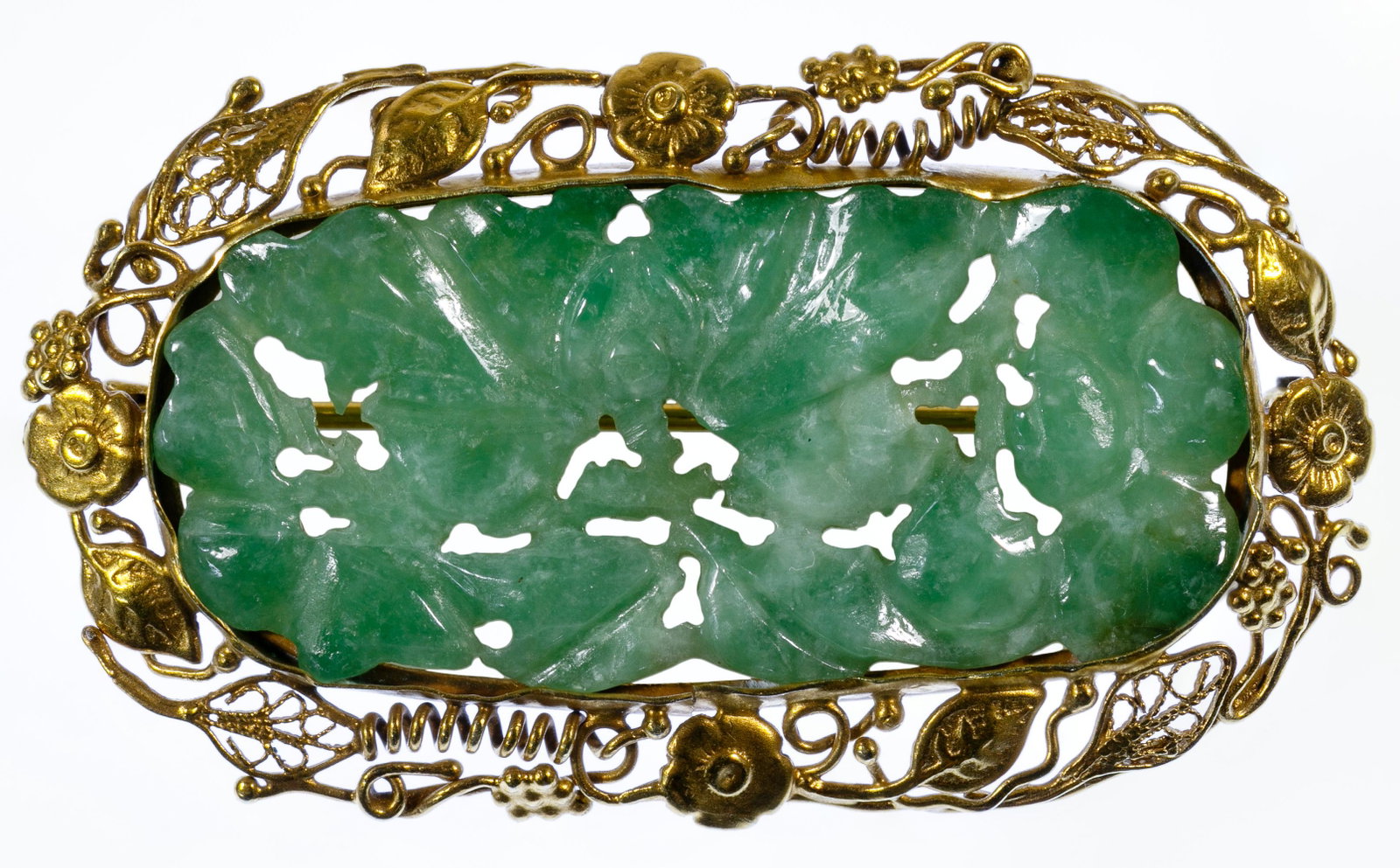14k Gold and Carved Jadeite Jade Brooch: 14k Gold and Carved Jadeite Jade Brooch Having an oval cut carved jadeite jade horizontally set, surrounded by a floral and open gold frame; marked '14k' on pin back catch Condition: Very Good, overal