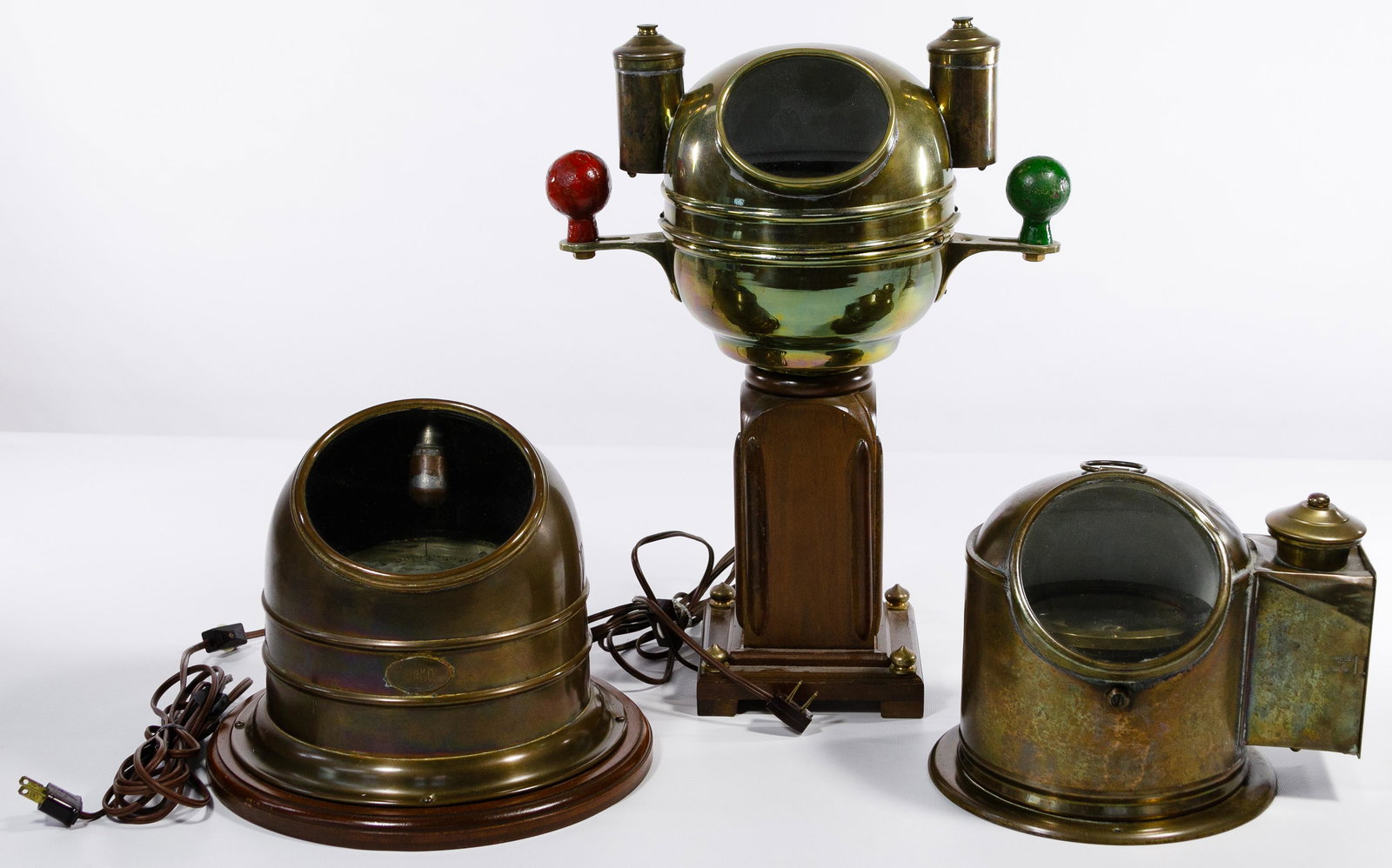 Nautical Binnacle Compass Assortment: Nautical Binnacle Compass Assortment Three items including a mounted Perkins Marine Lamp Corp, Trademark Perko, brass case with maker plaque, a Sestral brass rounded case with a viewing window, raised