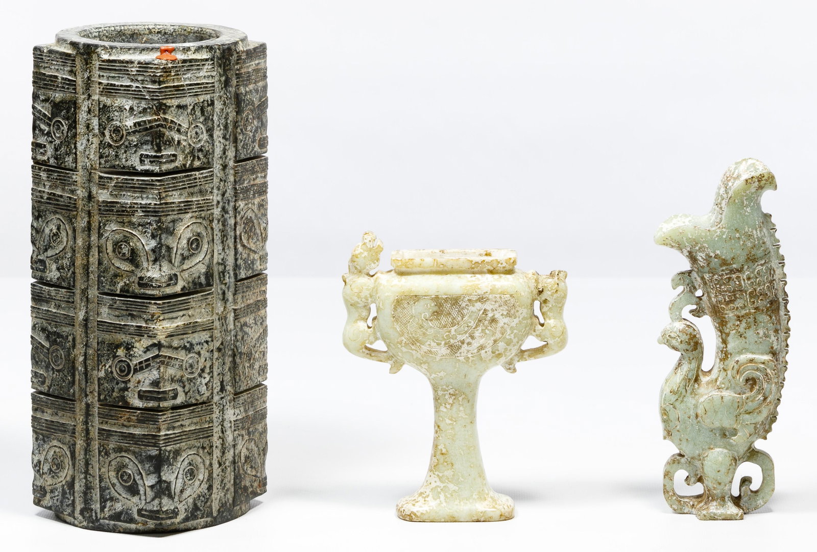 Chinese Jadeite Jade Cong and Nephrite Jade Vessel: Chinese Jadeite Jade Cong and Nephrite Jade Vessel Assortment Neolithic Hongshan style black jadeite cong having sixteen carved taotie masks at its corners and two Hongshan pale green nephrite vessels