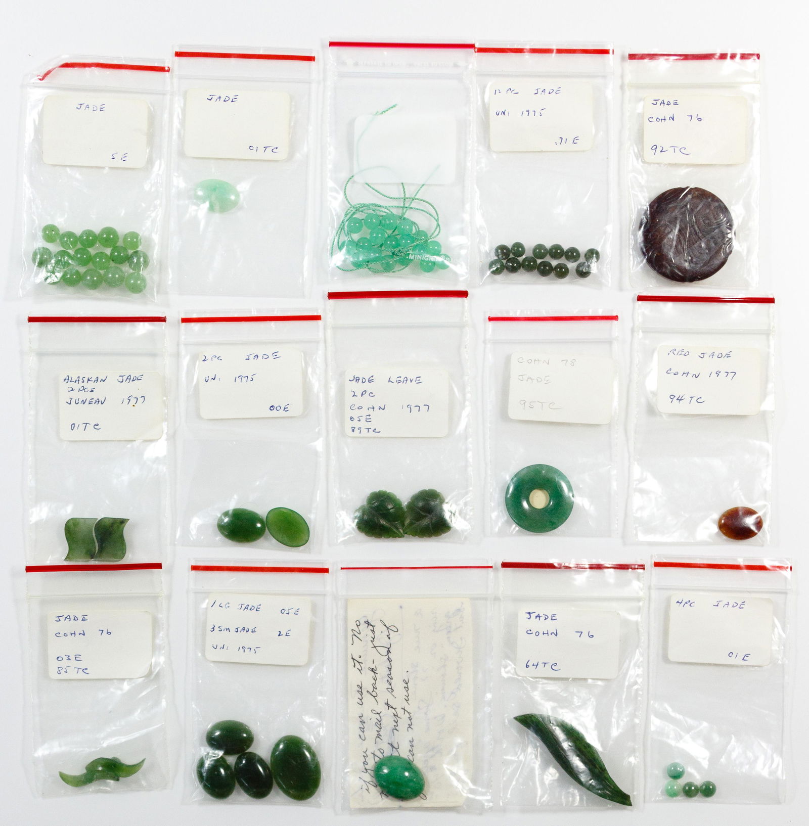 Jadeite Jade Assortment: Jadeite Jade Assortment Sixty-eight pieces including a carved brown disc-shaped pendant depicting a pair of fish, nine oval and four round cabochon pieces of various colors and sizes, forty-six beads,