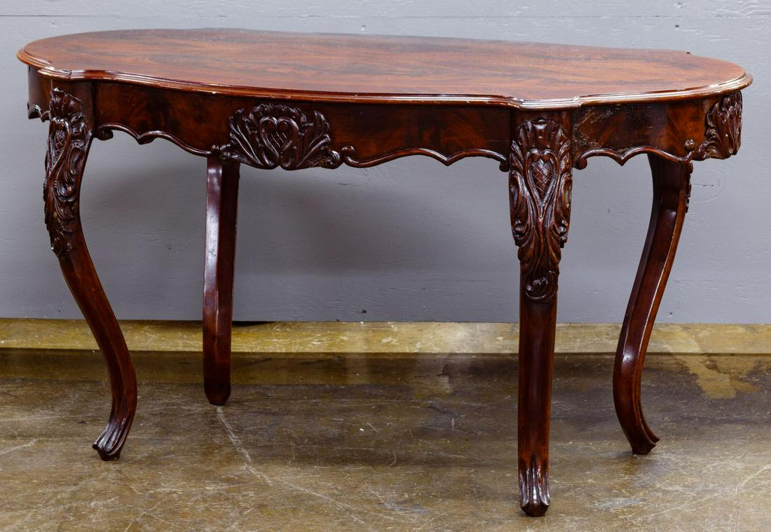 Flame Mahogany Veneer Library Table: Flame Mahogany Veneer Library Table Having an elongated turtle-top with carved skirt and cabriole legs Condition: Very Good, overall light wear consistent with age and normal use, minor loss to finish