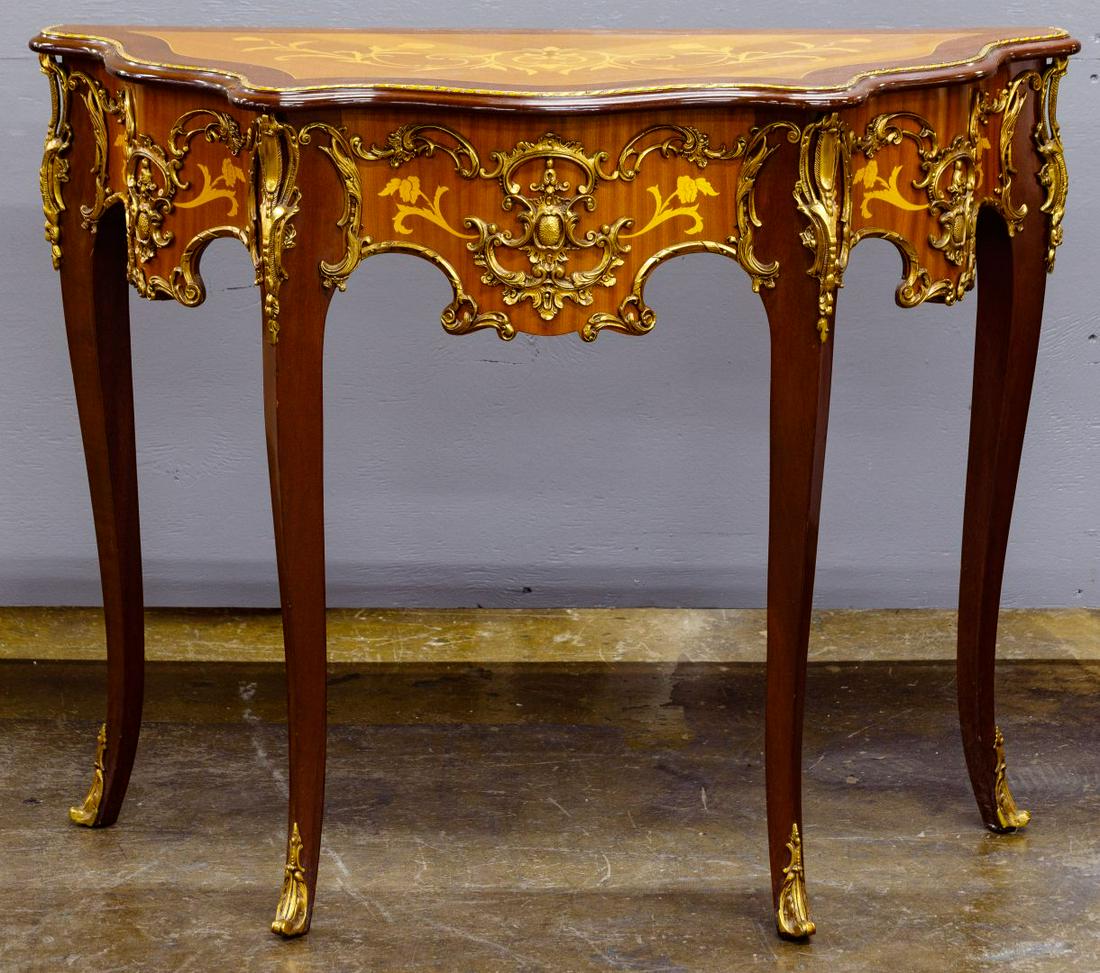 French Style Baroque Console Table: French Style Baroque Console Table Having duo-tone wood veneer, floral marquetry and ornate gold gilt applique decoration Condition: Very Good, overall light wear consistent with age and normal use; a