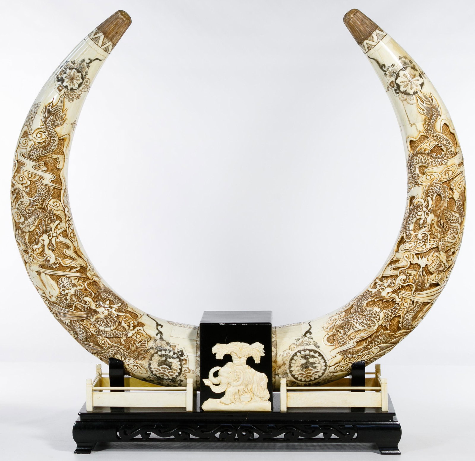 Asian Hand Carved Bone Horn Display: Asian Hand Carved Bone Horn Display Two horns having carved elephant and dragon motifs with stamped character marks on both horns; conjoined on a black wood and bone base with an elephant motif Condit
