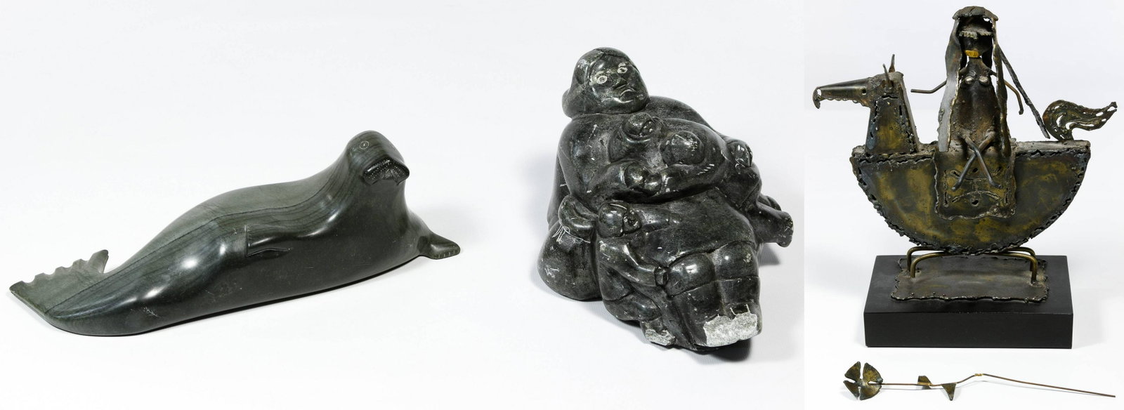 Inuit Carved Soapstone and Metal Statues: Inuit Carved Soapstone and Metal Statues Three items including a carved seal etched on the underside Josephie Niviaxie, community: Umiujaq; date: 1958; E-number: E9-2618; works: SC; a carved woman wit