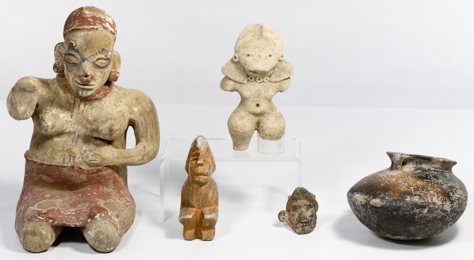 Pre-Columbian Style Assortment: Pre-Columbian Style Assortment Five items including a Jalisco Ameca style sitting female figure, Mezcala green stone 'Star Gazer' seated figure, Tlatilco cream-ware figure, Remojadas vera cruz head fr