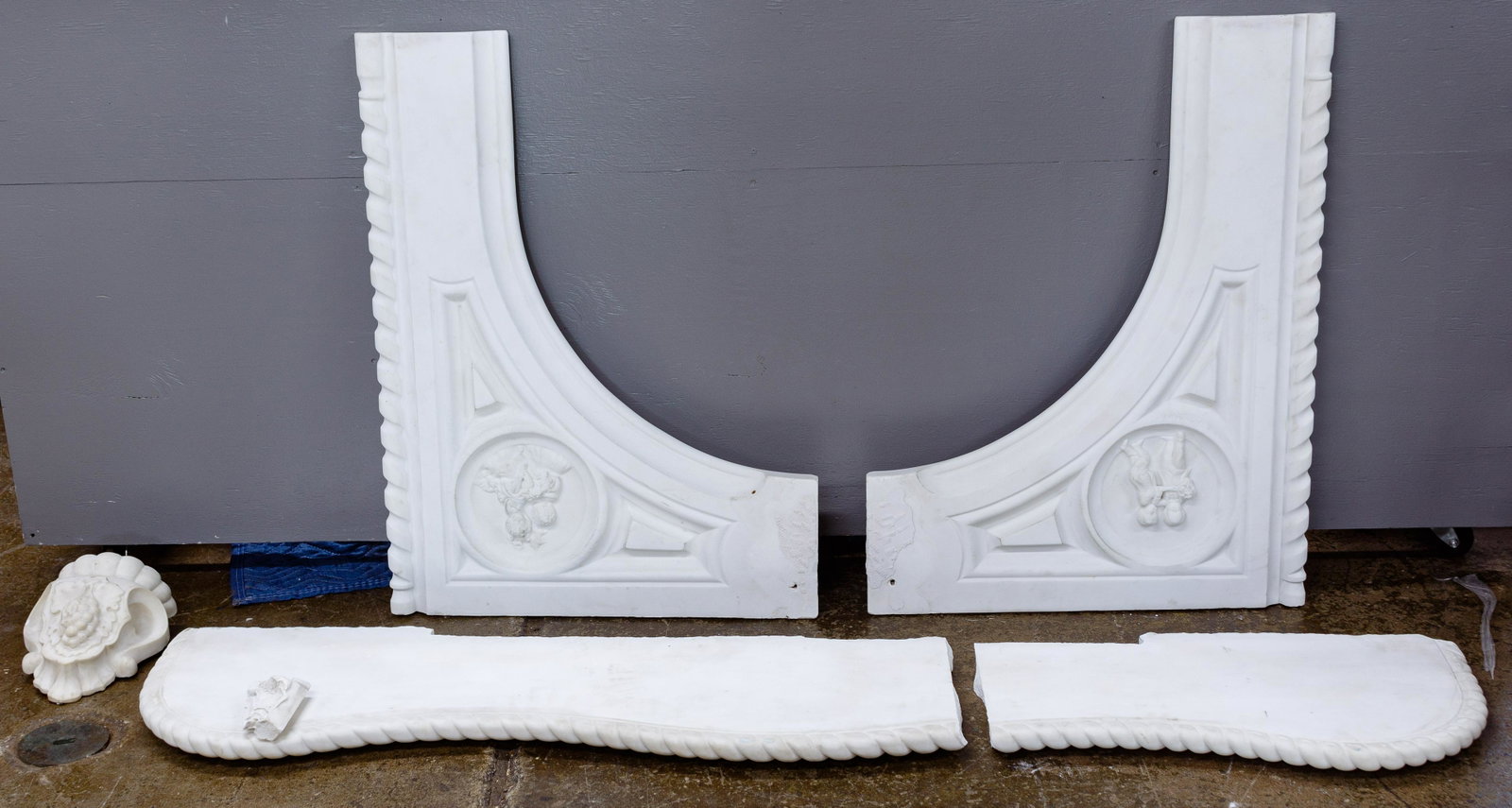 Marble Fireplace Mantle and Hearth: Marble Fireplace Mantle and Hearth Over fifteen pieces comprising a dismantled Victorian hearth and mantle having rope carved edges and back panels having carved relief medallions showing children at 