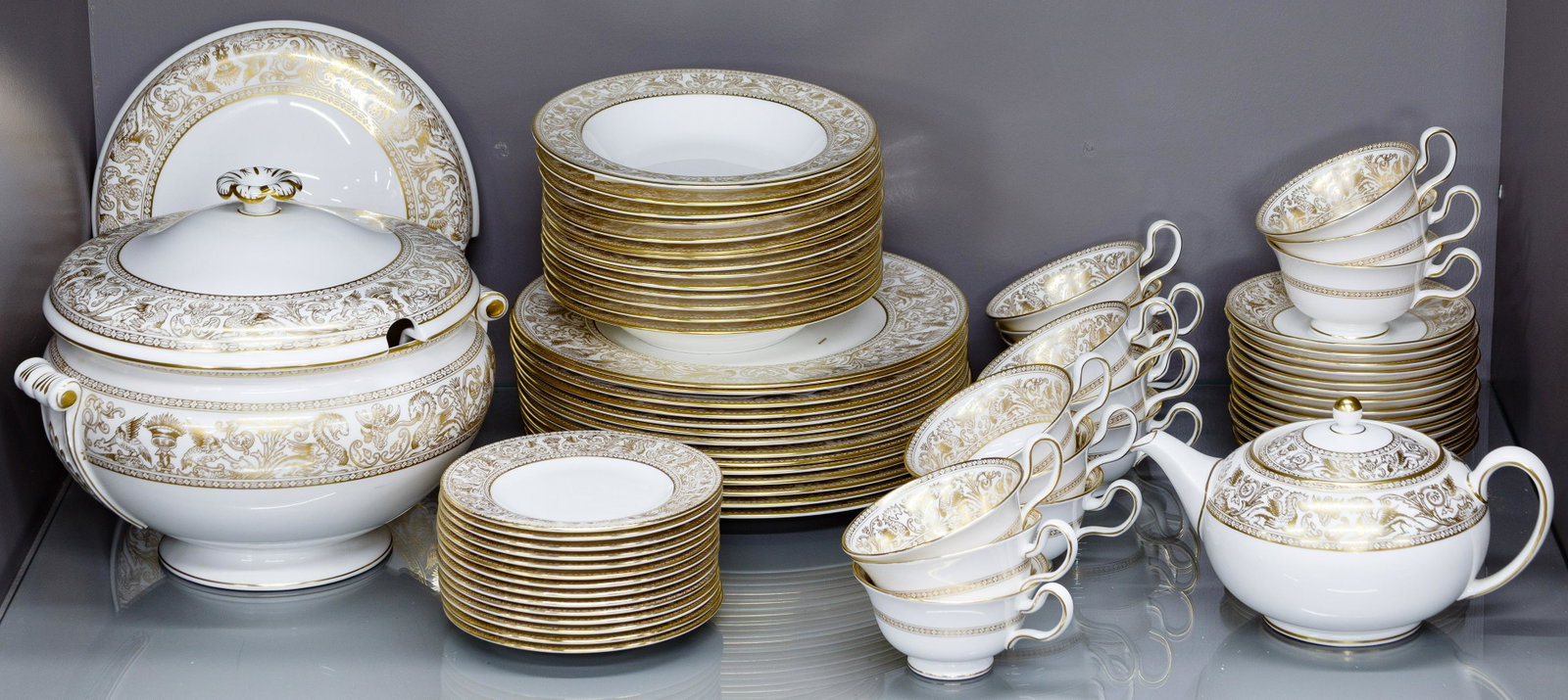 Wedgwood: Wedgwood 'Gold Florentine' China Service Forty six pieces including (14) dinner plates, (14) 8-inch rimmed soup bowls, (14) 6-inch salad / dessert plates, (15) teacups, (14) saucers, a teapot and a li