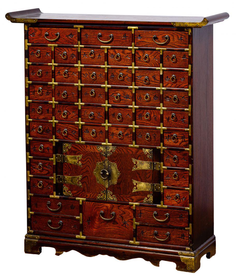 Asian Style Apothecary Cabinet: Asian Style Apothecary Cabinet 20th century having Asian character labels to each drawer and a brass pull in the center, brass corners, altar style top with spandrels; property from a Highland Park, I