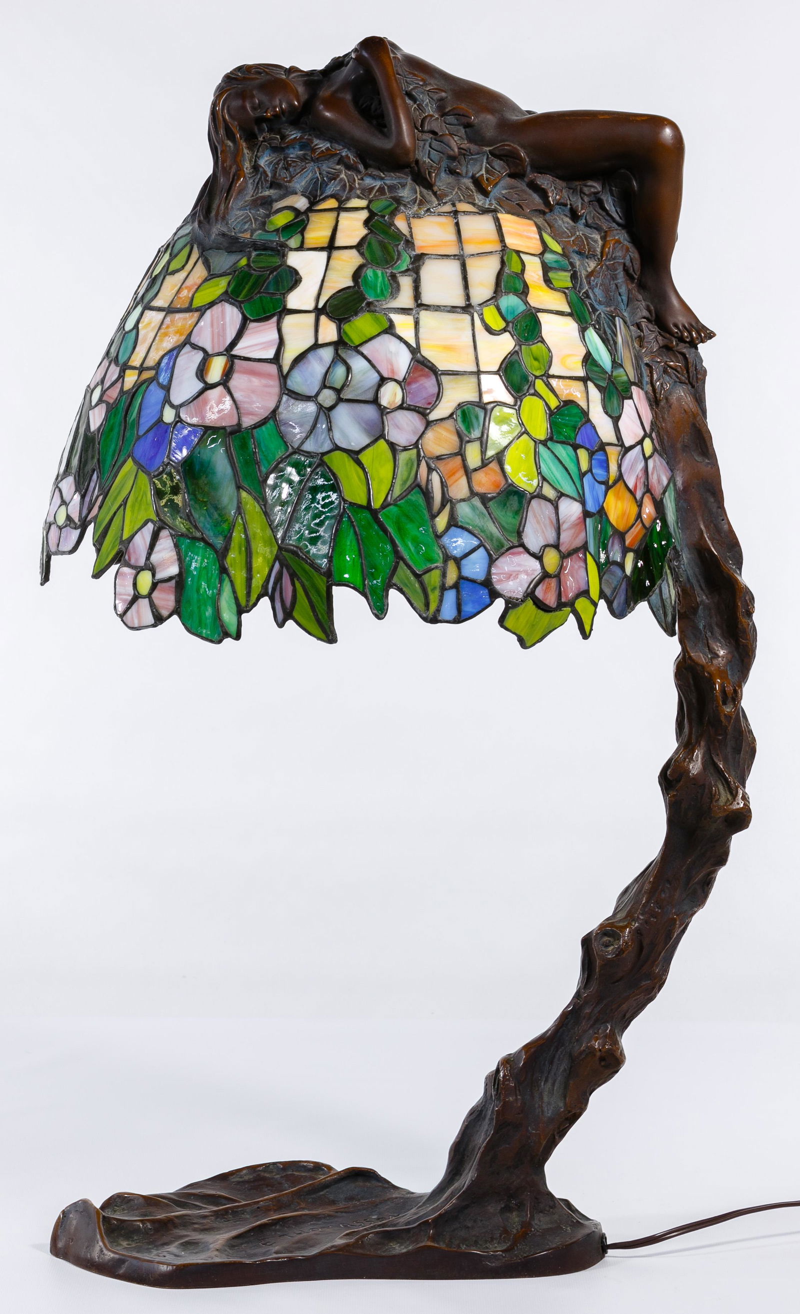 (After) Emil Thomasson (19th/20th Century) Bronze Lamp: (After) Emil Thomasson (19th/20th Century) Bronze and Stained Glass Lamp Undated, marked 'E. Thomasson' on base depicting a nude female figure atop a tree draped over a stained glass shade having a fl