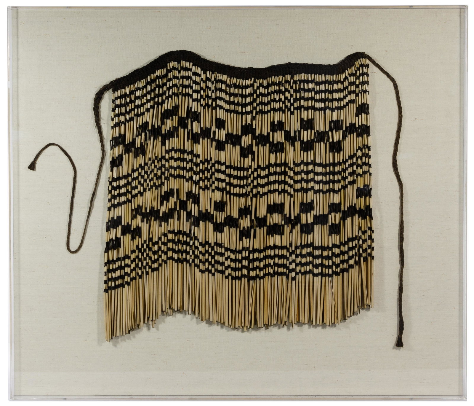 Maori Pui Pui Apron: Maori Pui Pui Apron 20th century Maori 'pui pui' apron skirt, consisting of woven fiber and split reeds; mounted to canvas on board in an acrylic frame; from the John Hancock Residences, Apartment 890