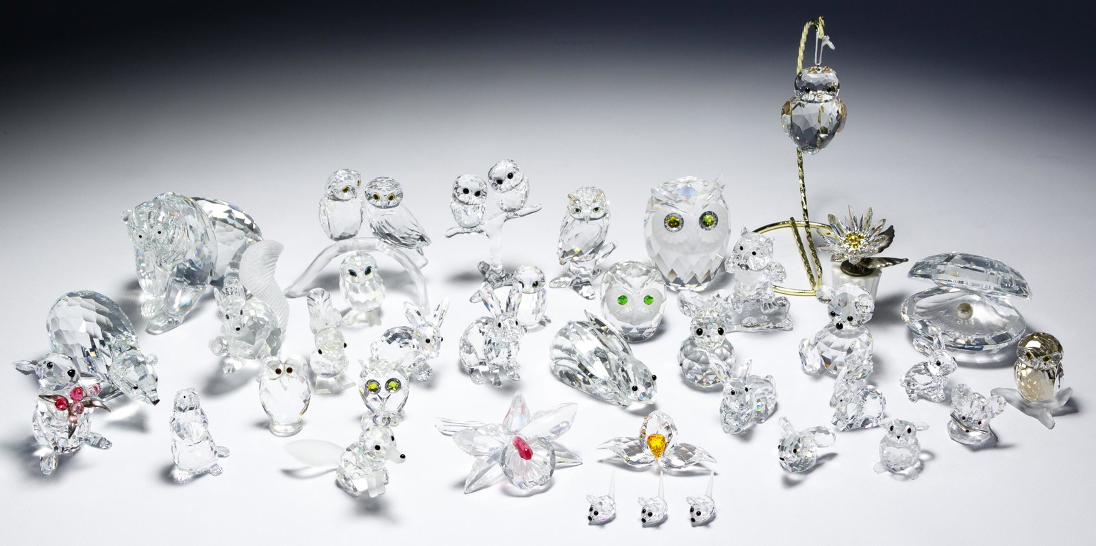 Swarovski Figurine Assortment: Swarovski Figurine Assortment (37) items including owls, bears, rabbits, mice, squirrels, a groundhog and a fox, three flowers and clam shell with pearl; all but five having Swarovski maker mark; one 