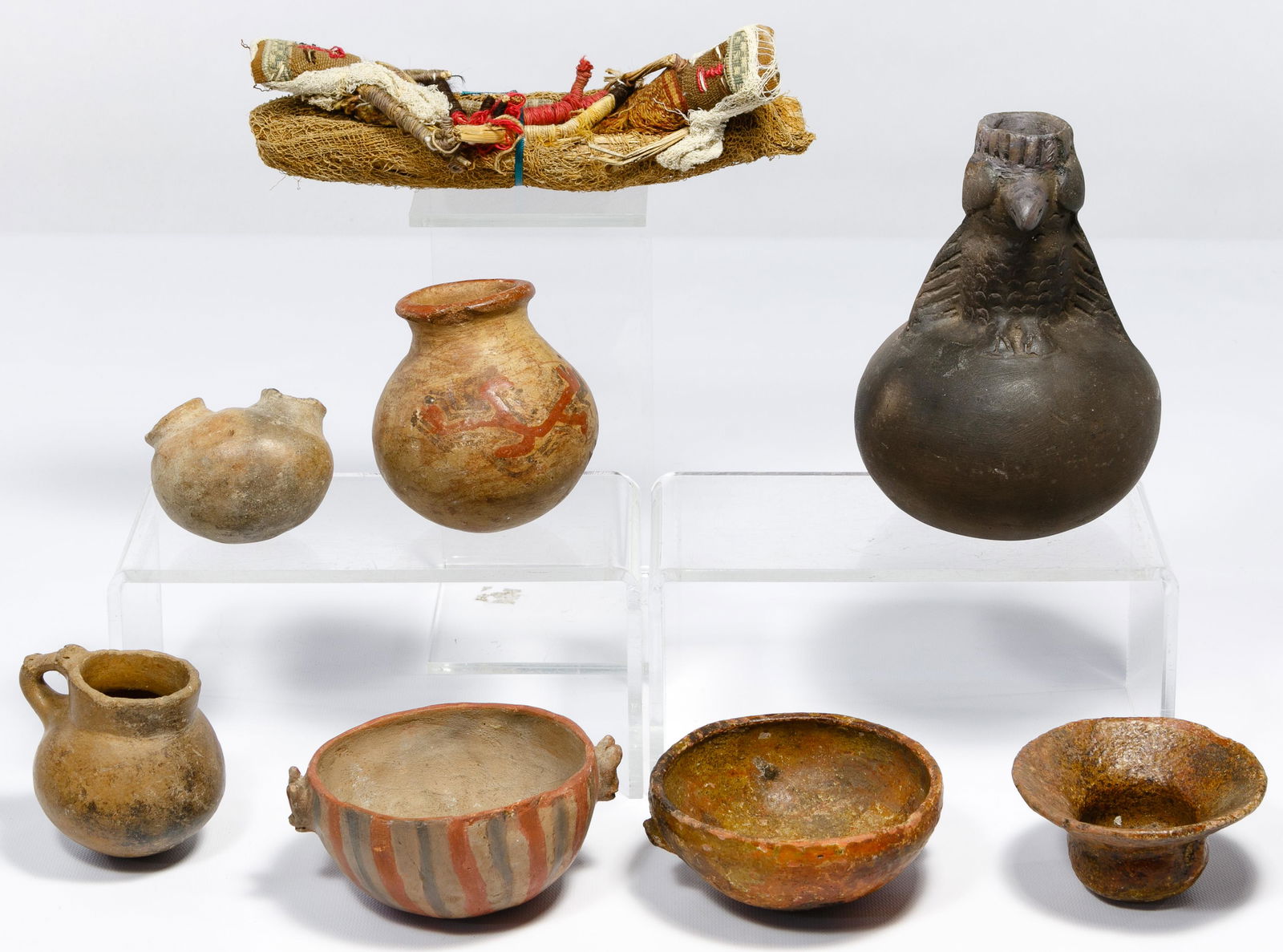 Pre-Columbian Style Pottery Assortment: Pre-Columbian Style Pottery Assortment (7) examples including a Moche style owl effigy bottle, a Mayan style vertically striped painted bowl having animal head handles and gold toned flecks in its cla