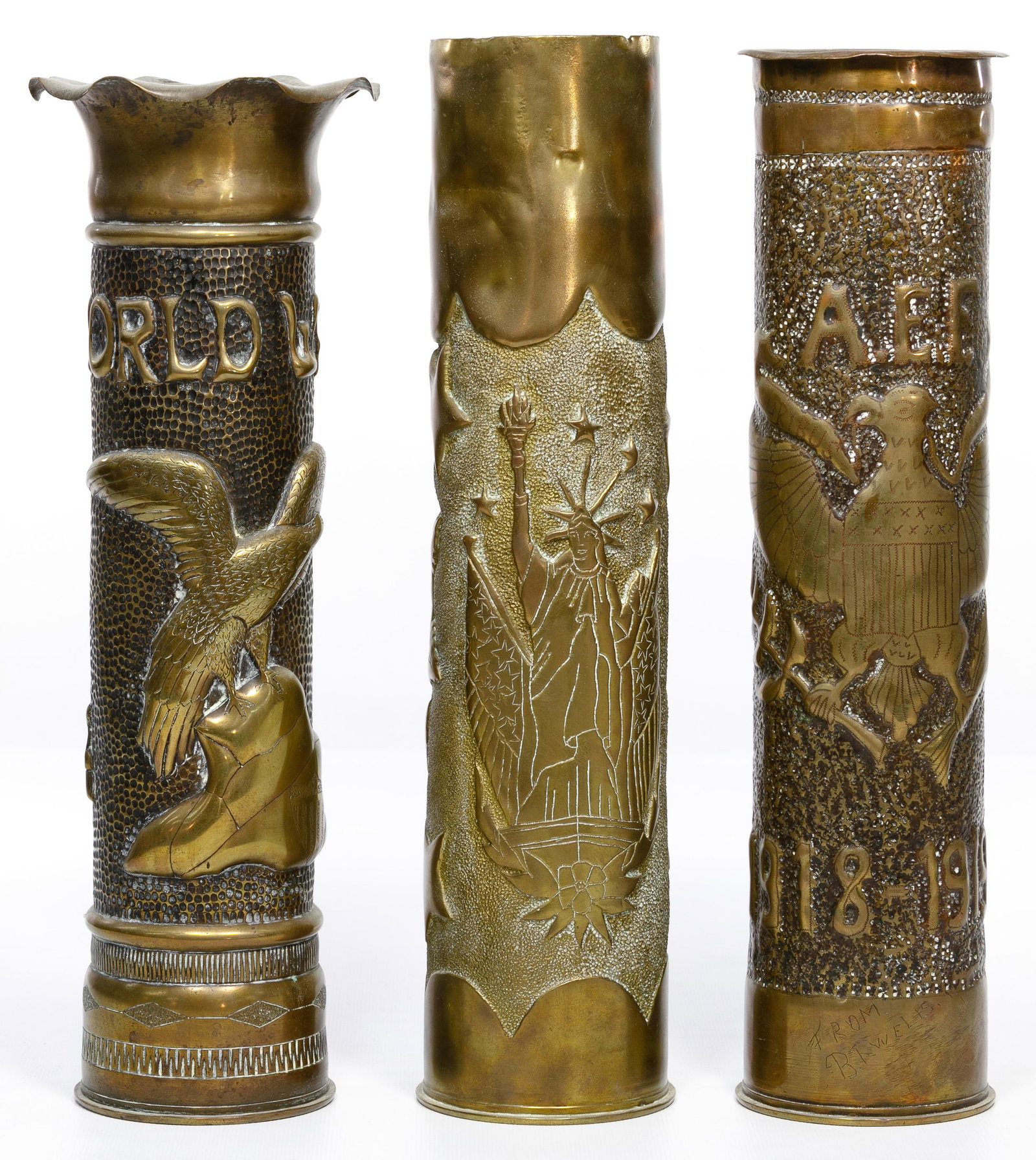 World War I 75mm Artillery Trench Art: World War I 75mm Artillery Trench Art (3) brass shell casing vases including one inscribed 'World War' having and eagle perched on a rock; second having the statue of liberty with a large rose embosse