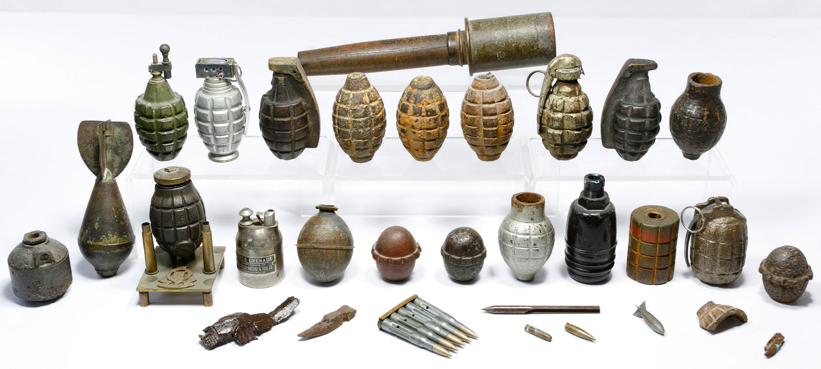 World War I Grenade Assortment: World War I Grenade Assortment (31) items including American training, German egg, a stick grenade, steel rifle, tail fin, trench art grenade on a brass stand having army medal and pieces of shrapnel