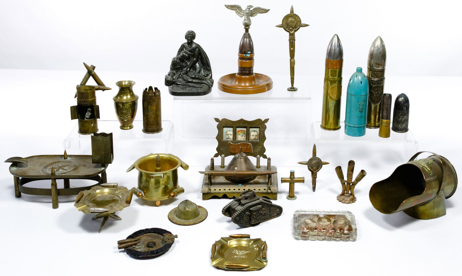 World War I Trench Art Assortment: World War I Trench Art Assortment (24) items including an iron military bookend, (6) ashtrays, photograph inkwell, crucifixes, banks, (3) paperweights, pen holder, miniature coal bucket and cartridges