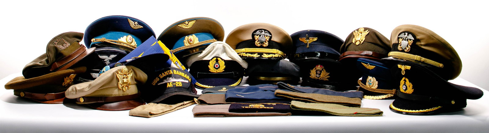 Military Hat / Cap Assortment: Military Hat / Cap Assortment (27) examples including (16) peaked caps from World War II US Air Transport Command khaki crusher, Bancroft USN officer, Bernard USN Commander, (2) Lancaster US Army crus