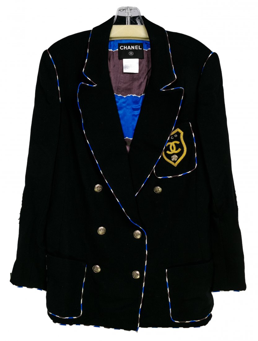 Coco Chanel Badge Wool Blazer: Coco Chanel Badge Wool Blazer Black blazer / jacket in a thin wool having gray, white, blue silk trim front and back; silk lining with chain hem detail, a pocket having gold and silver sequin logo bad