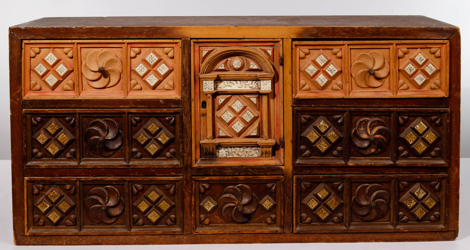 Primitive Apothecary Cabinet: Primitive Apothecary Cabinet Stained cabinet having color washed geometric and floral carved front with (7) drawers surrounding a door Property from: a Chicago (Lincoln Park), Illinois estate Height: 