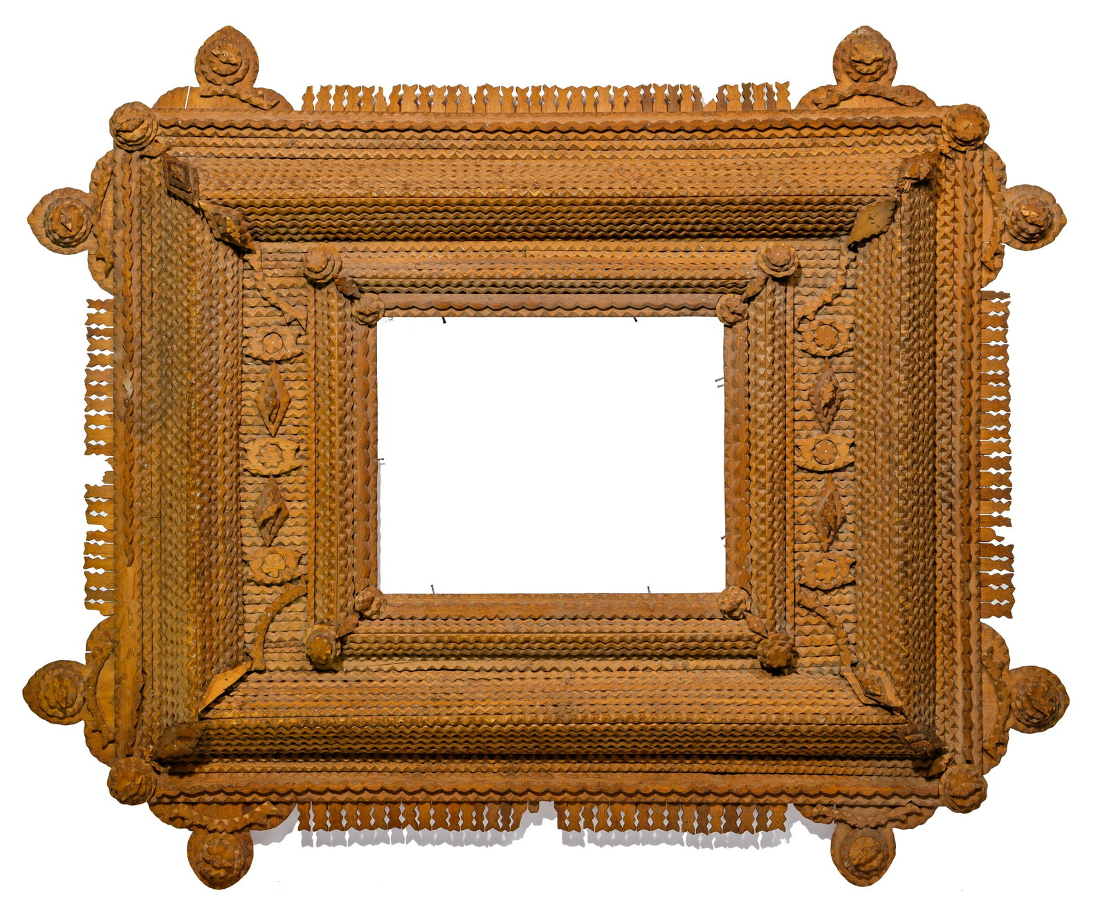 Tramp Art Frame: Tramp Art Frame Pyramid style having circular, diamond, curved and geometric accent shapes, assembled using stacked wood boards having chip carved edges; picket fence style edge between rounded corner