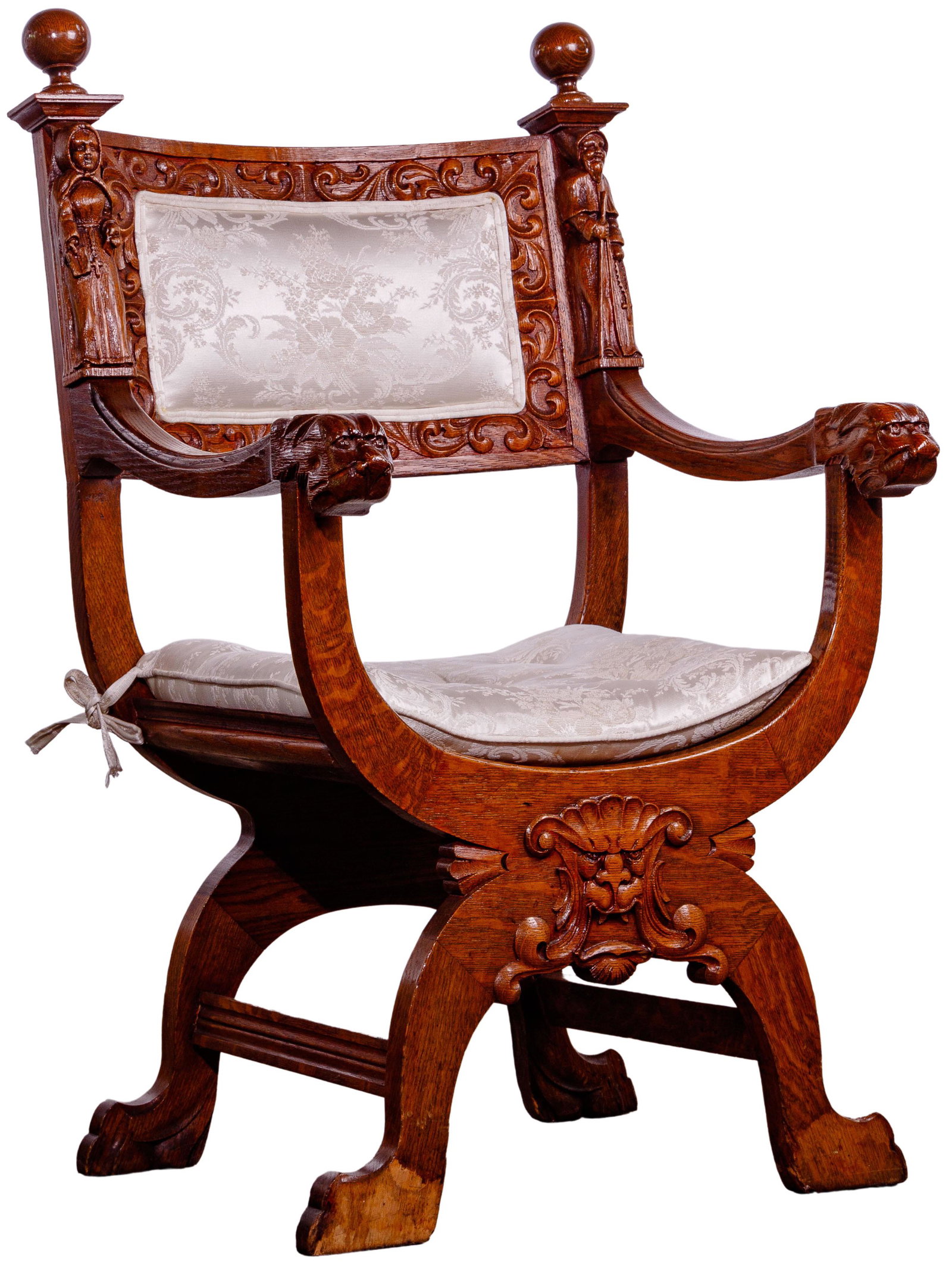 Dagobert-Style Carved Oak Curule Chair: Dagobert-Style Carved Oak Curule Chair Tiger oak carved lion arm chair; having intricate swirls and figural carvings around seat back and on front leg and seat joint; corded white damask fabric seat c