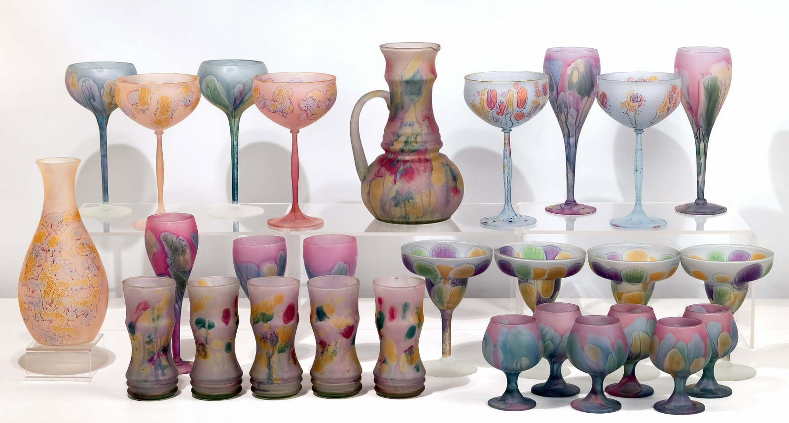 Nouveau Art 'Reuven' Glass Assortment: Nouveau Art 'Reuven' Glass Assortment (29) handblown items having a frosted satin finish in a subtle rainbow of flowing colors including (5) cooler glasses and matching pitcher; (11) wine glasses of v